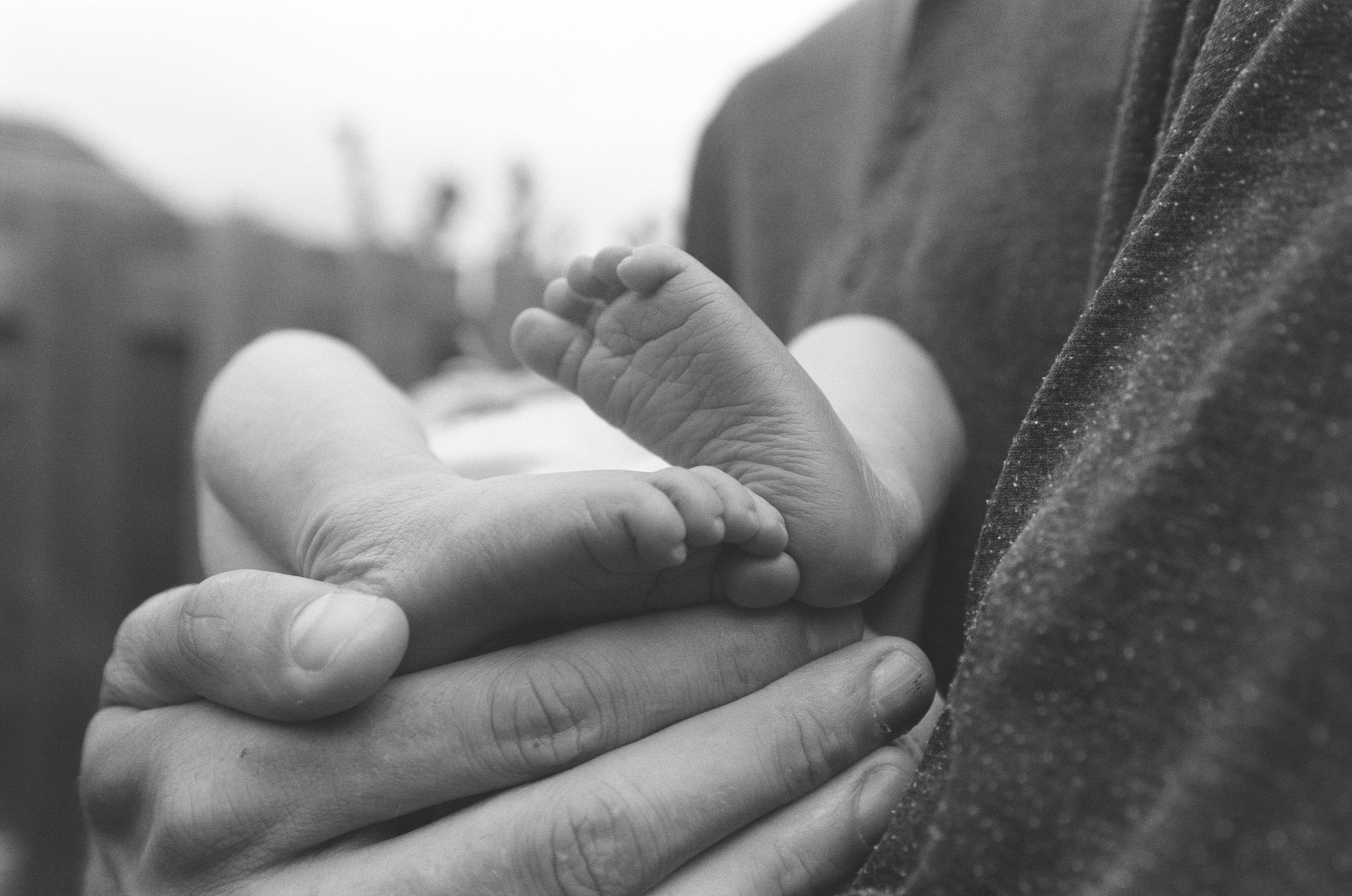 a-mans-large-hand-cradles-a-newborn-baby.jpg